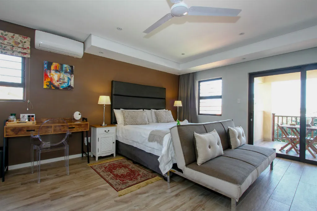 Modern bedroom with bed sofa desk and balcony view