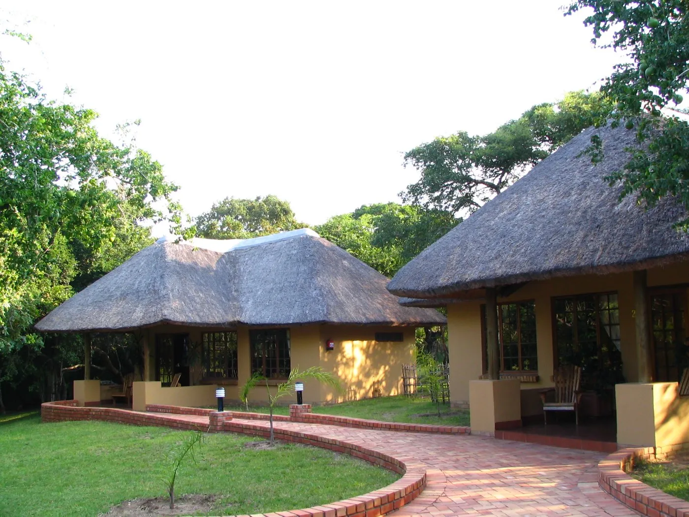 Traditional thatchedroof huts in a lush garden setting