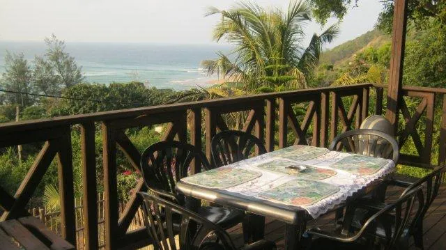 Outdoor dining area with ocean view and tropical plants