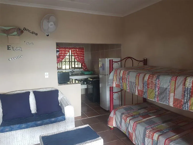 Cozy room with sofa bunk beds and kitchen view through a small doorway