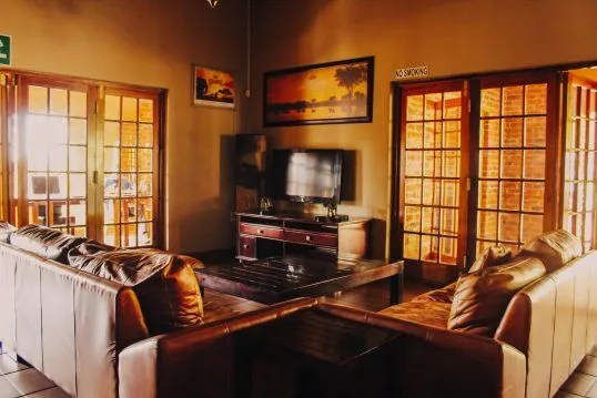 Cozy living room with leather sofas TV and large windows