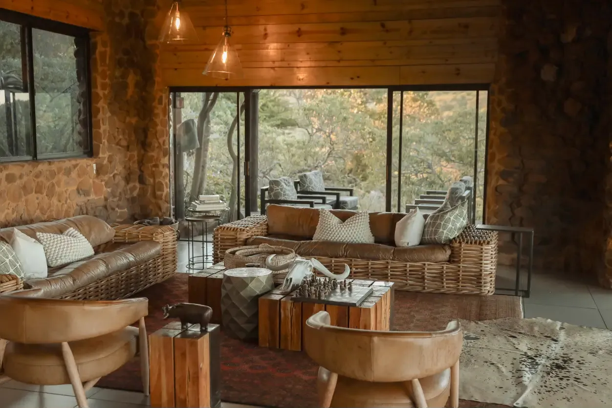 Cozy wooden lodge interior with sofas stone walls and large windows