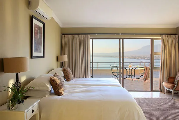 Bedroom with two beds large windows and a scenic outdoor view