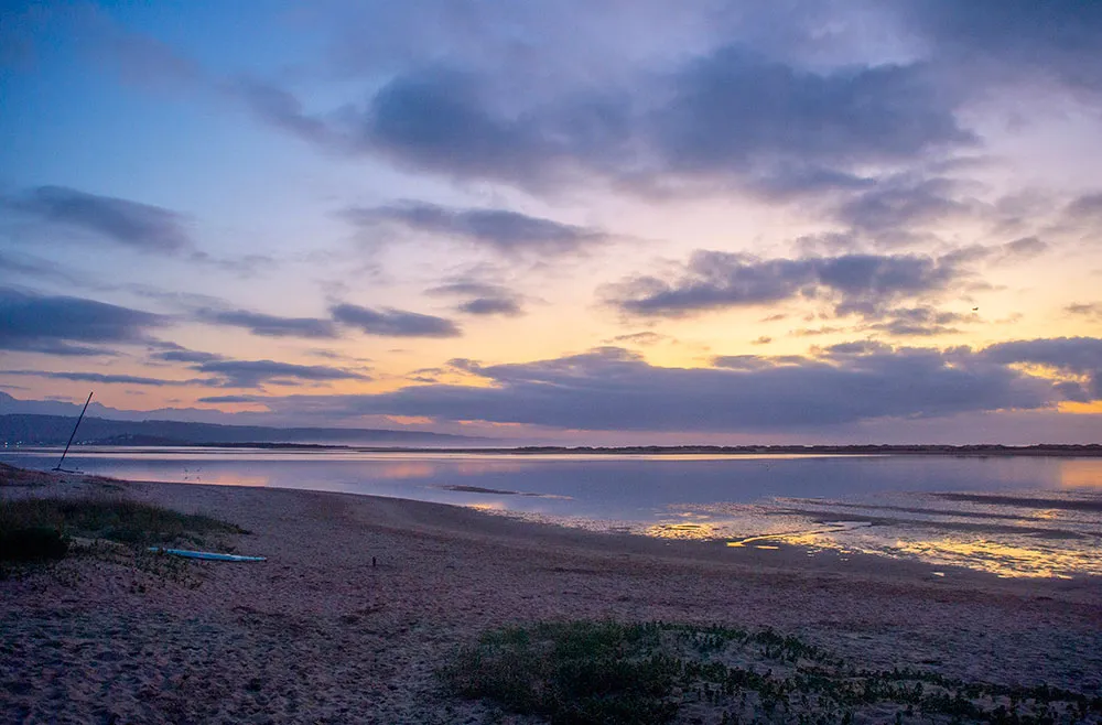 Beach at sunset with scattered clouds and calm water