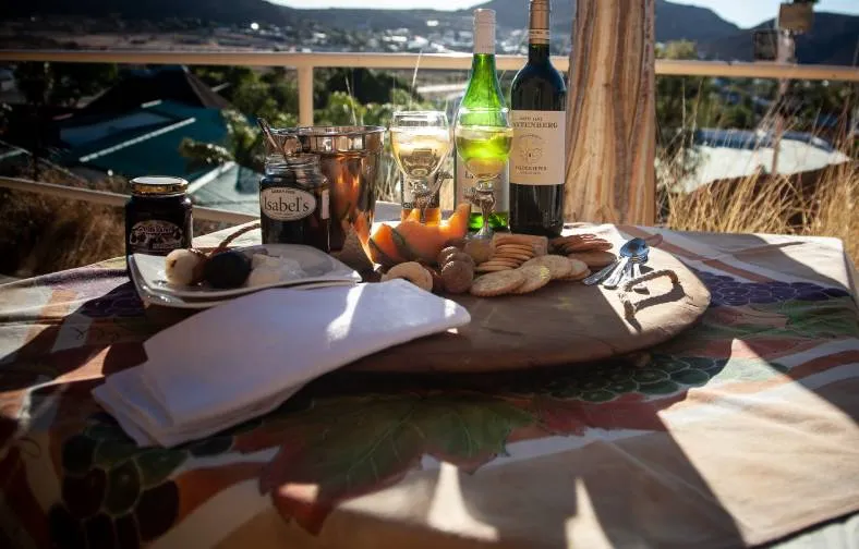 Outdoor picnic with wine cheese bread and glasses on a patterned tablecloth
