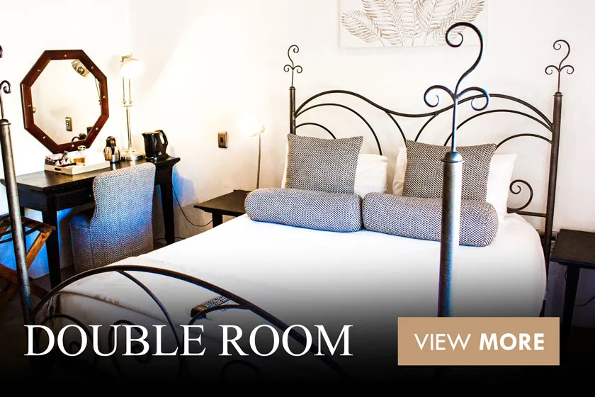 Cozy bedroom with a double bed ornate headboard and a vanity mirror