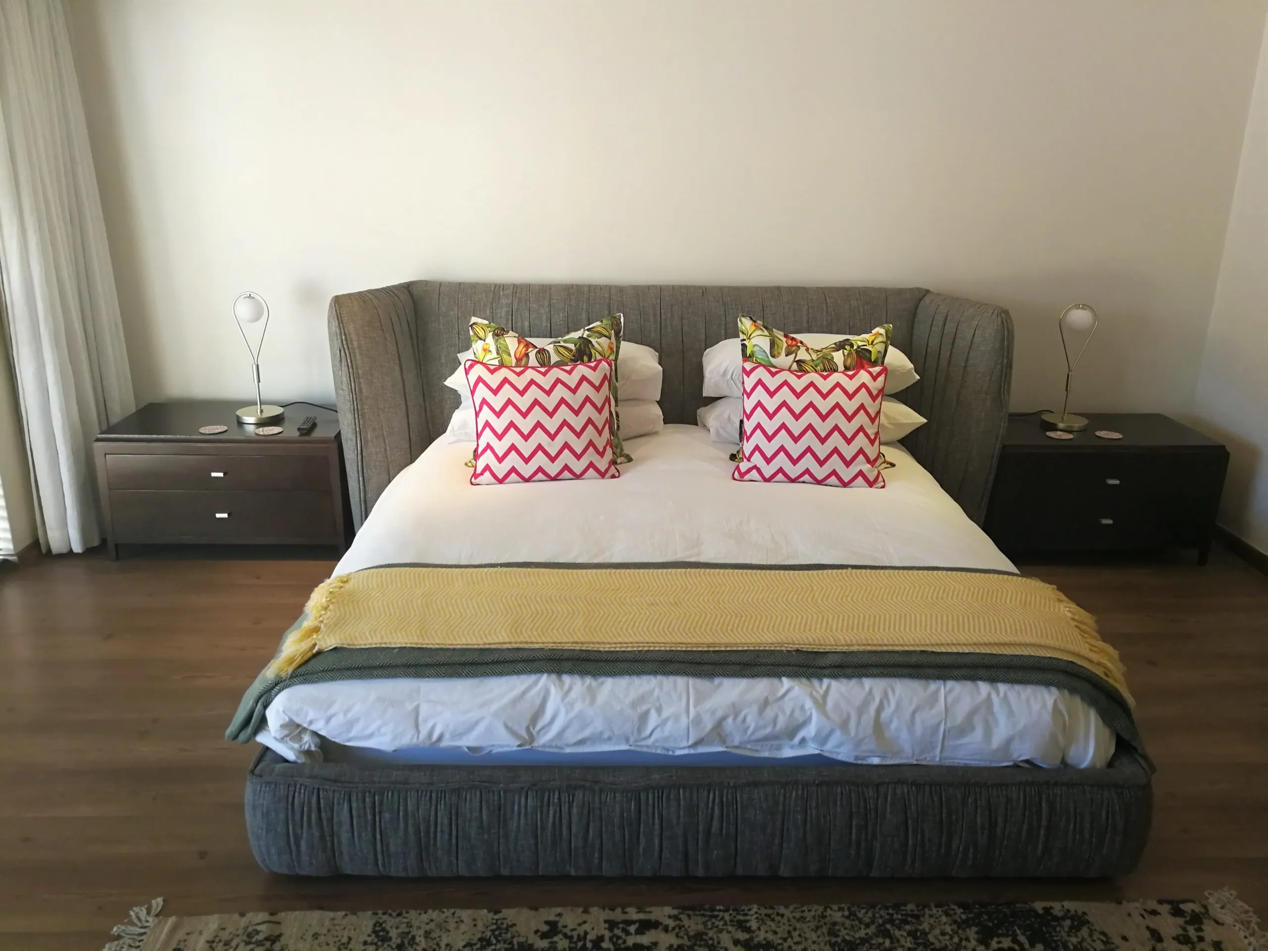 Modern bedroom with large bed patterned pillows and bedside tables with lamps