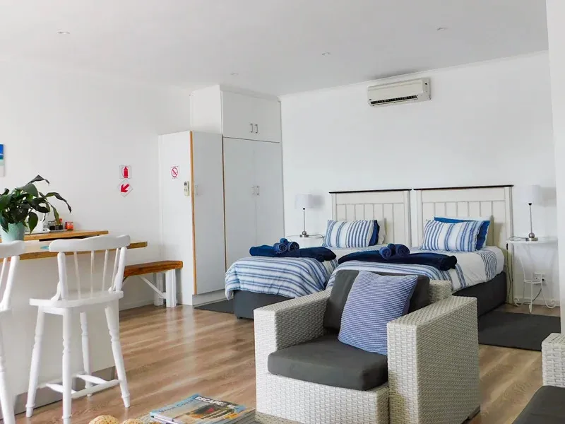 Cozy bedroom with twin beds armchair and wooden furniture on a wooden floor