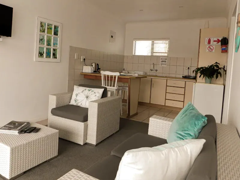 Cozy living room with kitchenette TV and wicker furniture