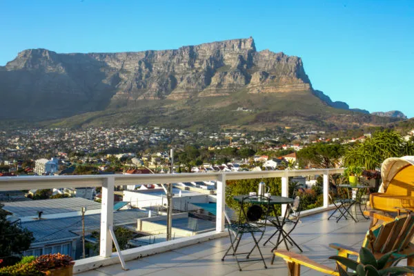 Mountain view from a balcony with chairs and tables in a residential area