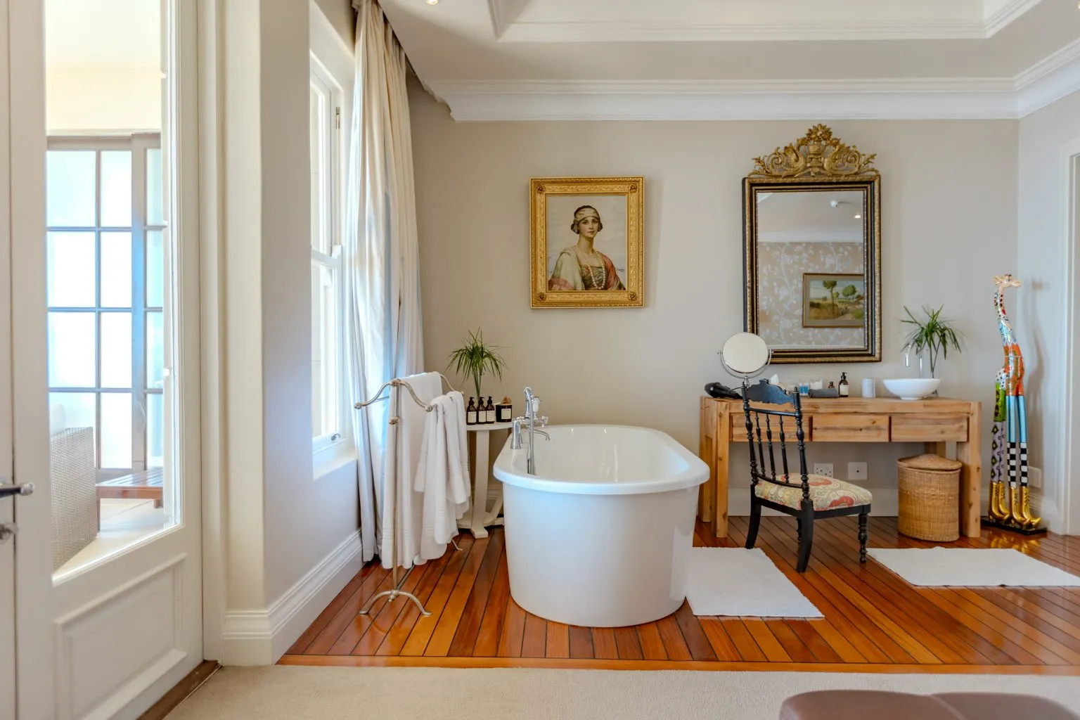 Freestanding bathtub in a stylish bathroom with wooden floor and decor