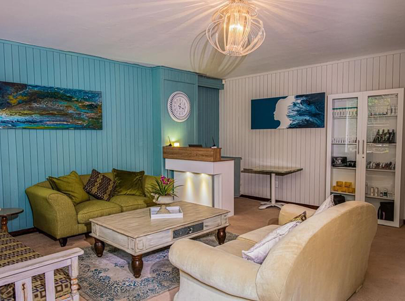 Reception area with sofa, coffee table, and modern decor in blue and white.