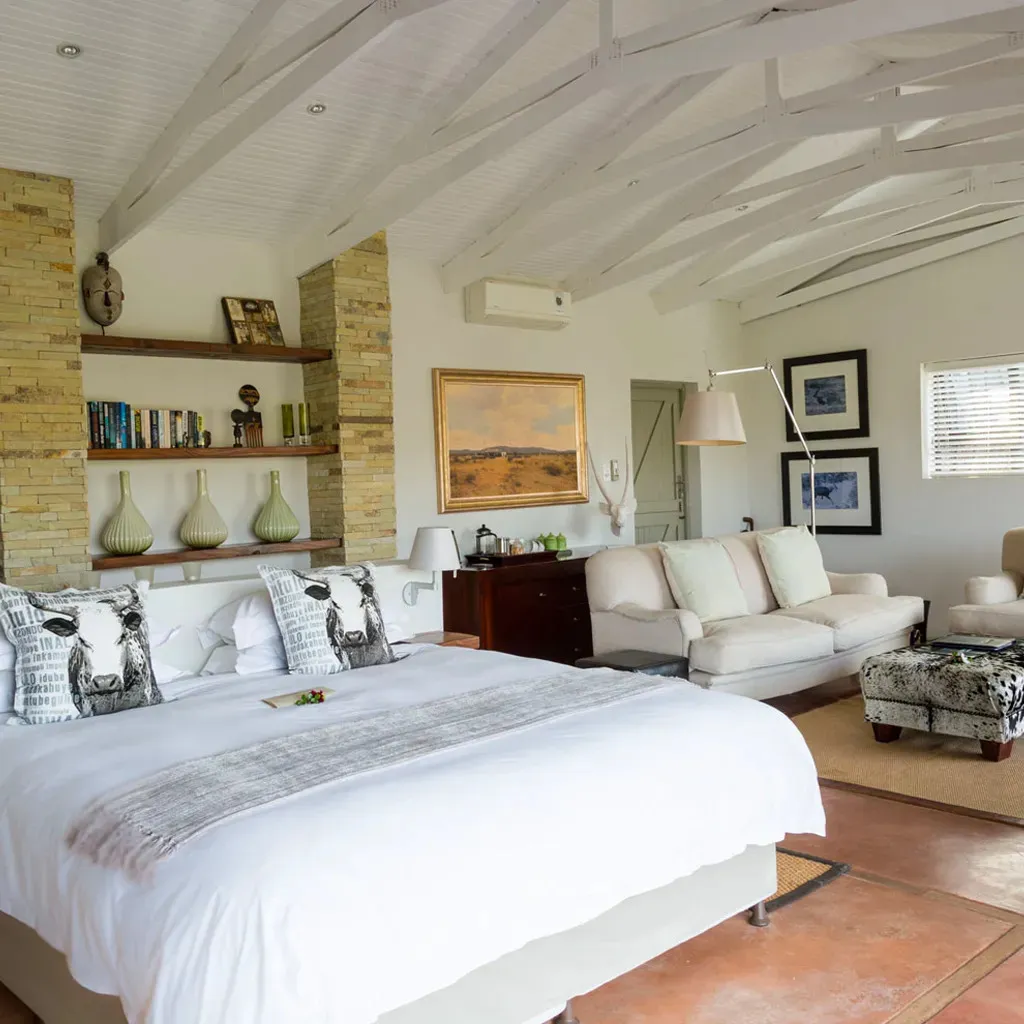 Bedroom with a large bed cowprint decor and a cozy seating area