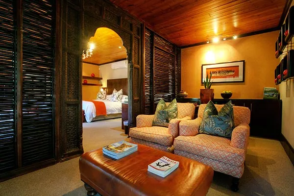 Cozy living room with armchairs ottoman and view of bedroom through archway