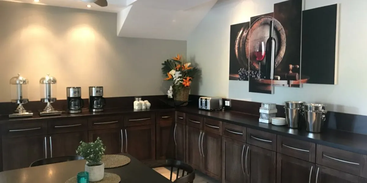 Modern kitchen with dark wood cabinets coffee makers and winethemed artwork