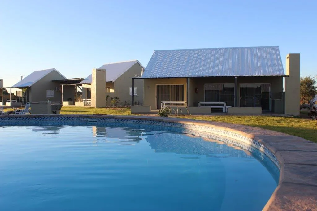 Modern cabins with a swimming pool in a sunny grassy area