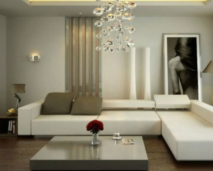 Modern living room with white sectional sofa chandelier and large blackandwhite artwork