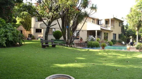 Large house with pool and wellmaintained garden with trees and shrubs