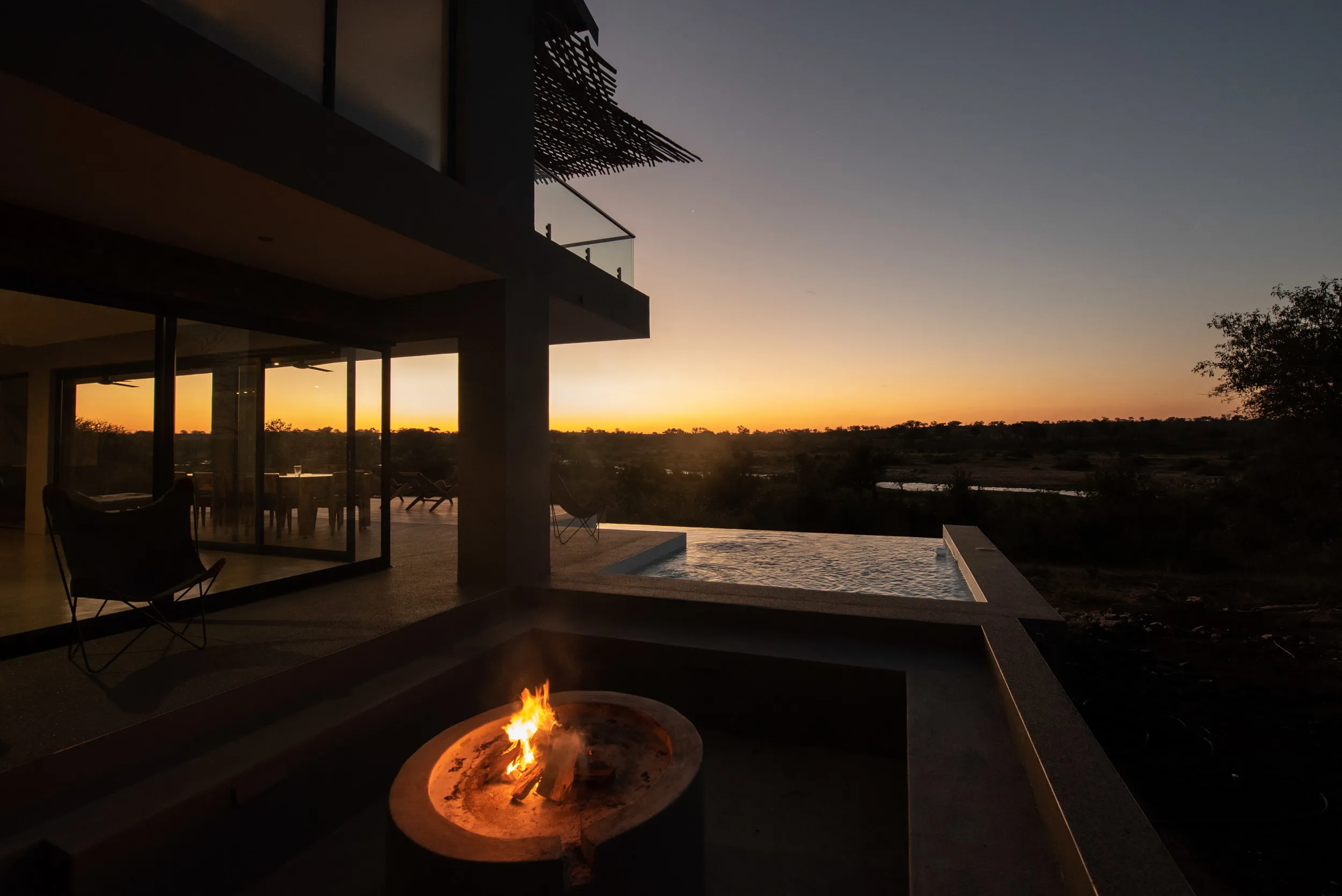 Modern house with fire pit pool and sunset view over a landscape