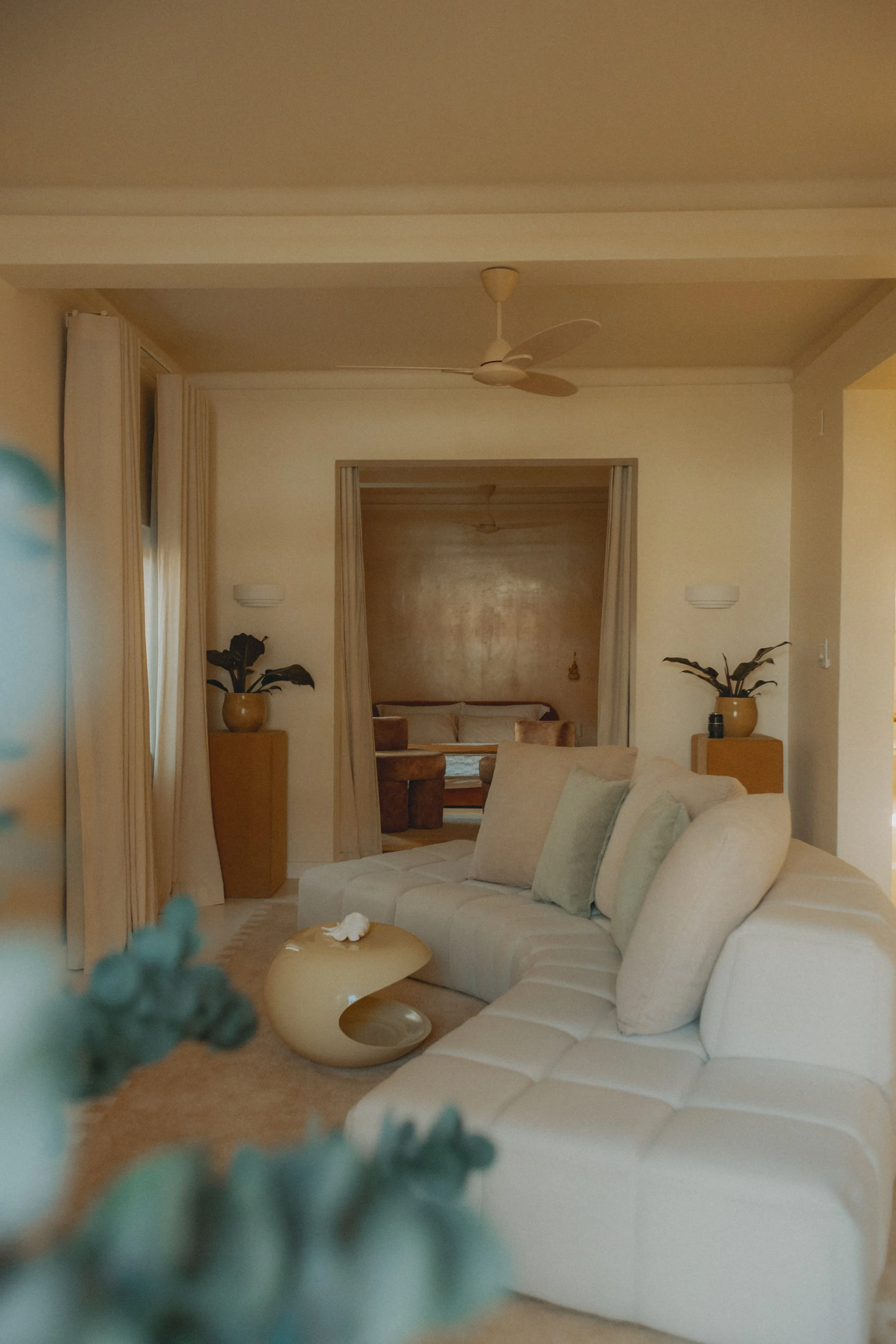 Modern living room with white sectional sofa plants and soft lighting