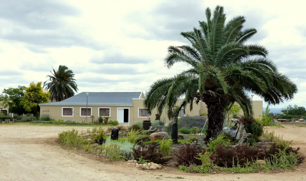 Singlestory house with garden and palm trees in a rural setting
