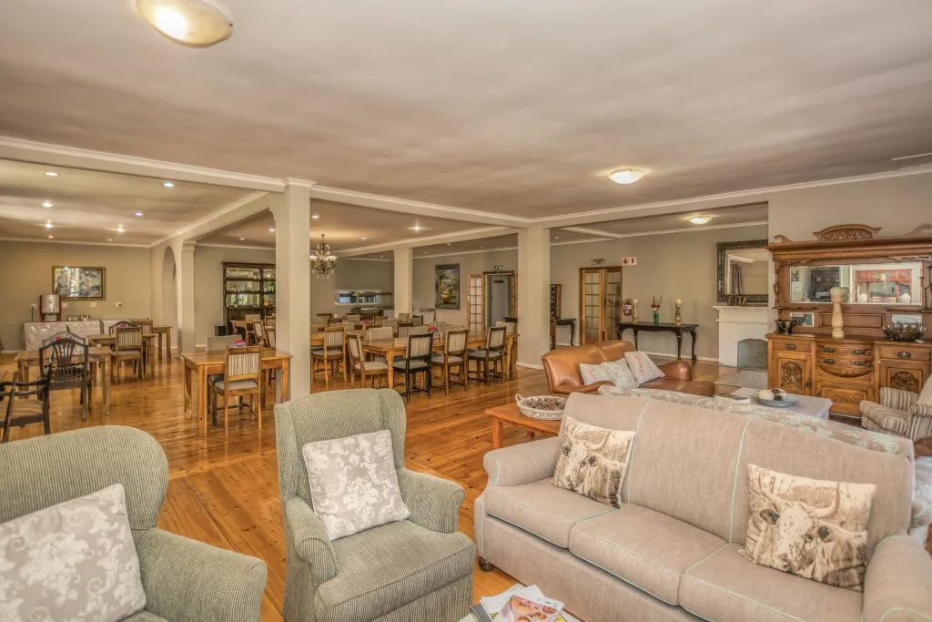 Cozy living room with sofas armchairs and a dining area in the background