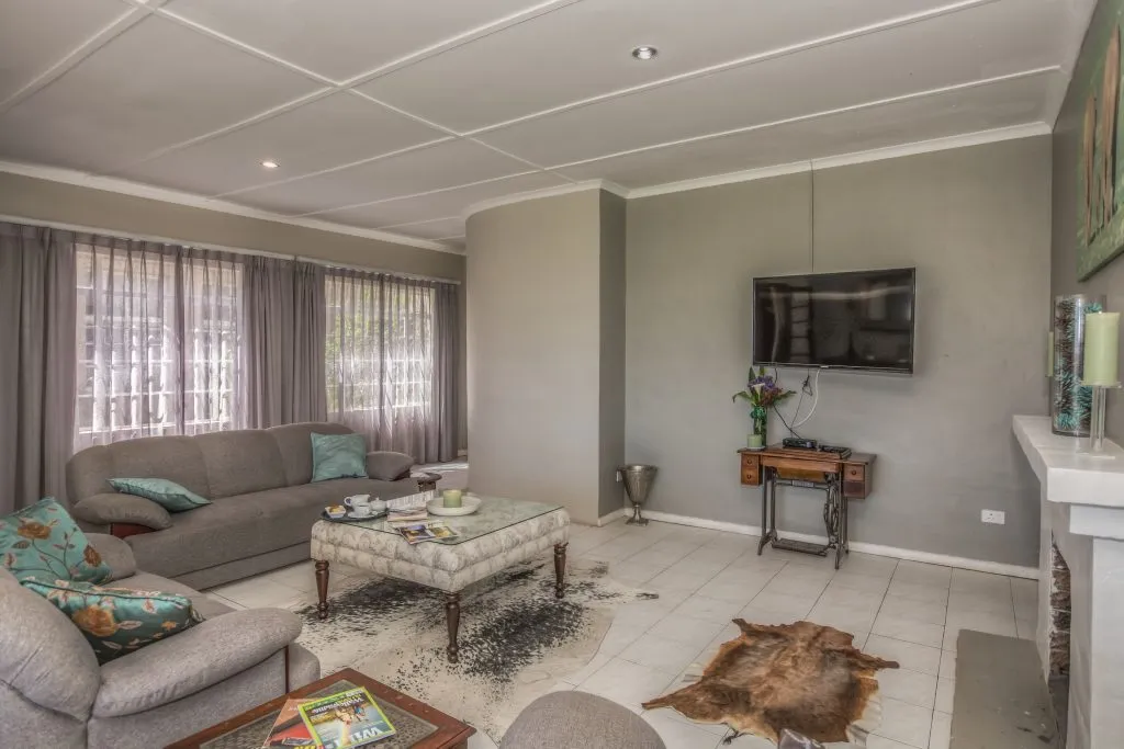 Modern living room with grey furniture TV fireplace and large windows