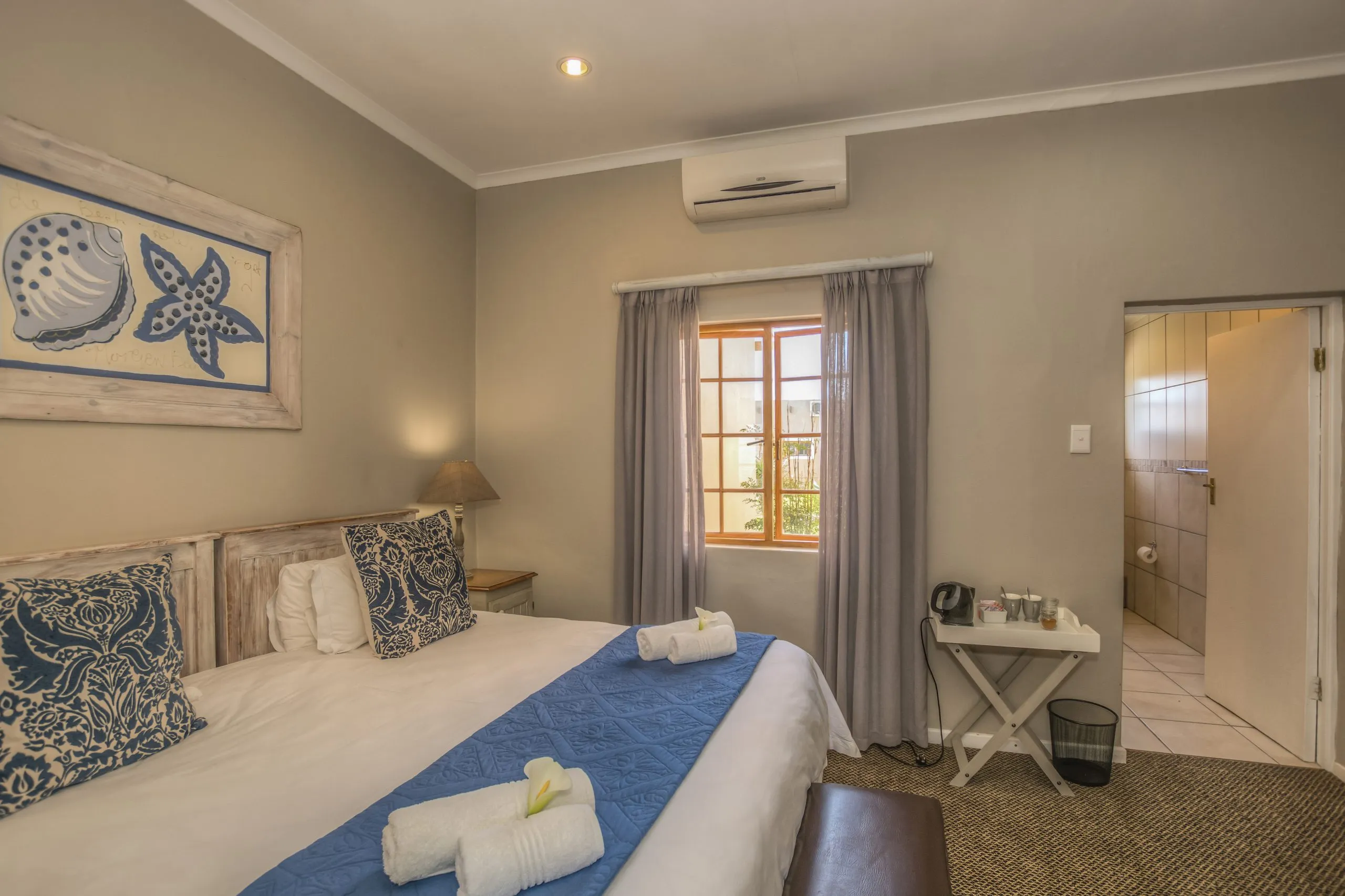 Cozy bedroom with a neatly made bed window and adjacent bathroom