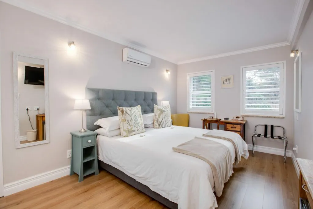 Cozy bedroom with a large bed nightstand desk and wooden floor