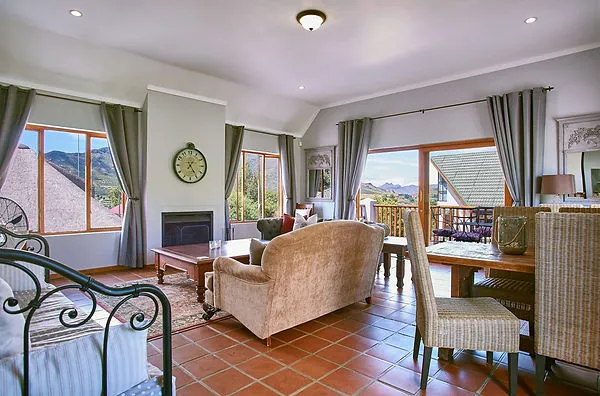 Cozy living room with large windows tiled floor and mountain view