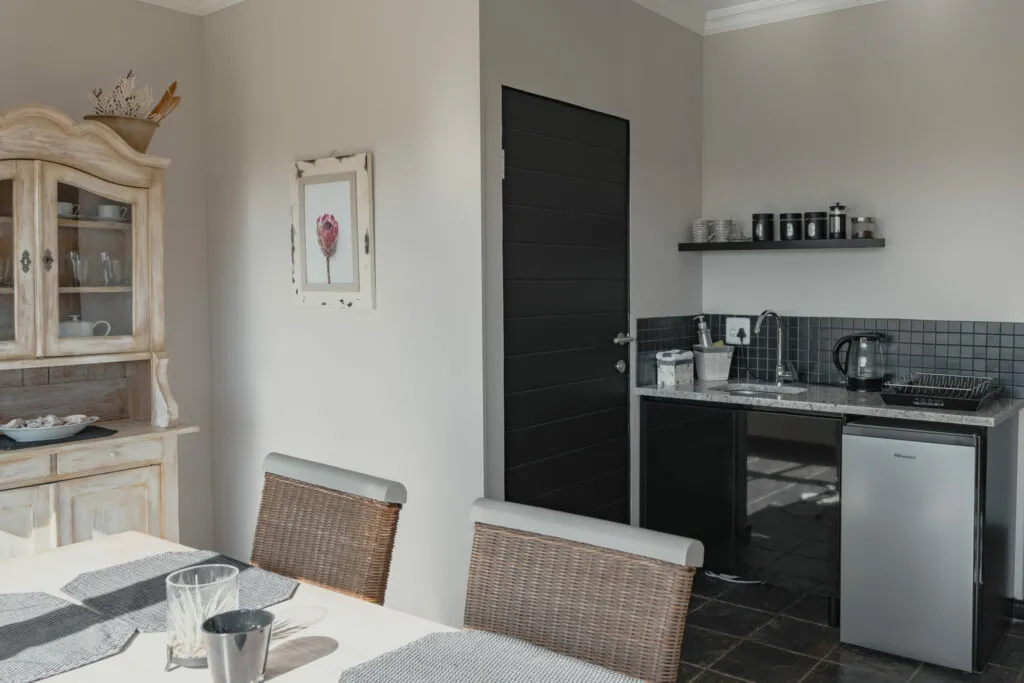 Dining area with table and chairs next to a small kitchenette
