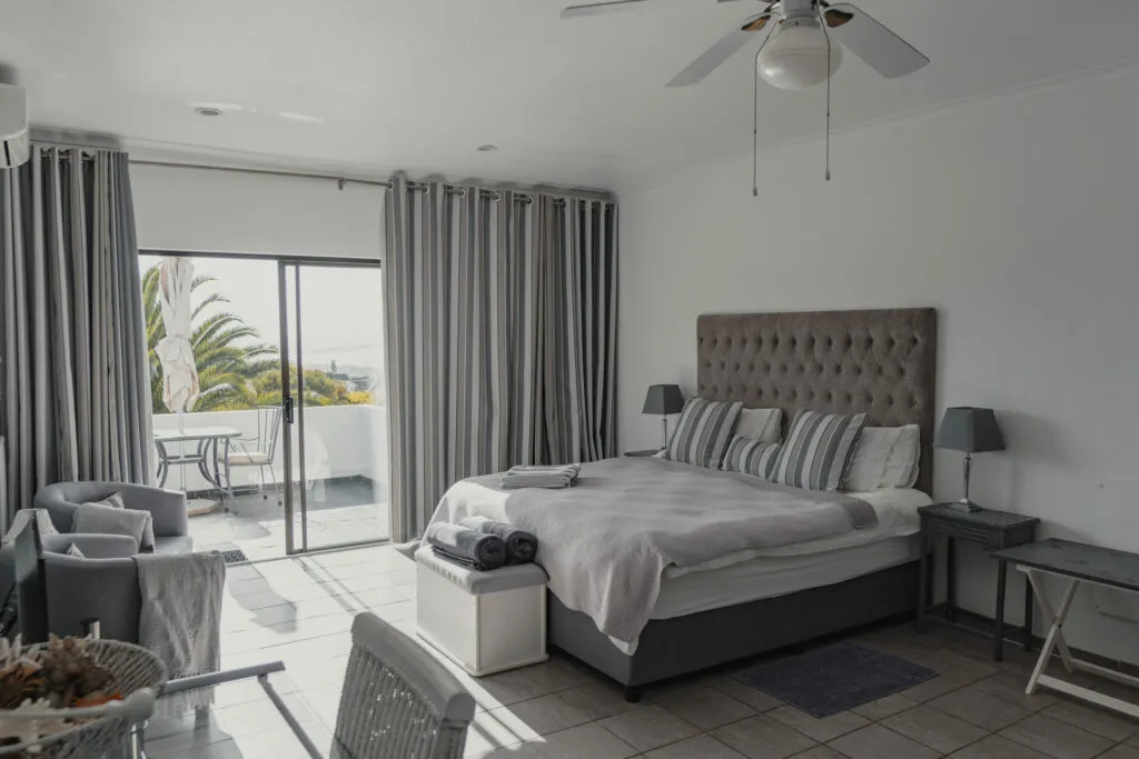 Modern bedroom with large bed curtains and sliding door to balcony