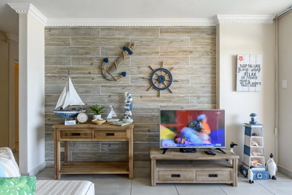 Wooden nauticalthemed decor with TV model sailboat and lighthouse figurine in living room