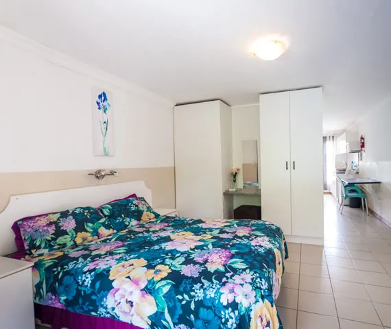 Bedroom with floral bedspread white wardrobe and vanity table