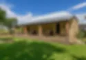 Blurred image of a building with a green lawn and blue sky