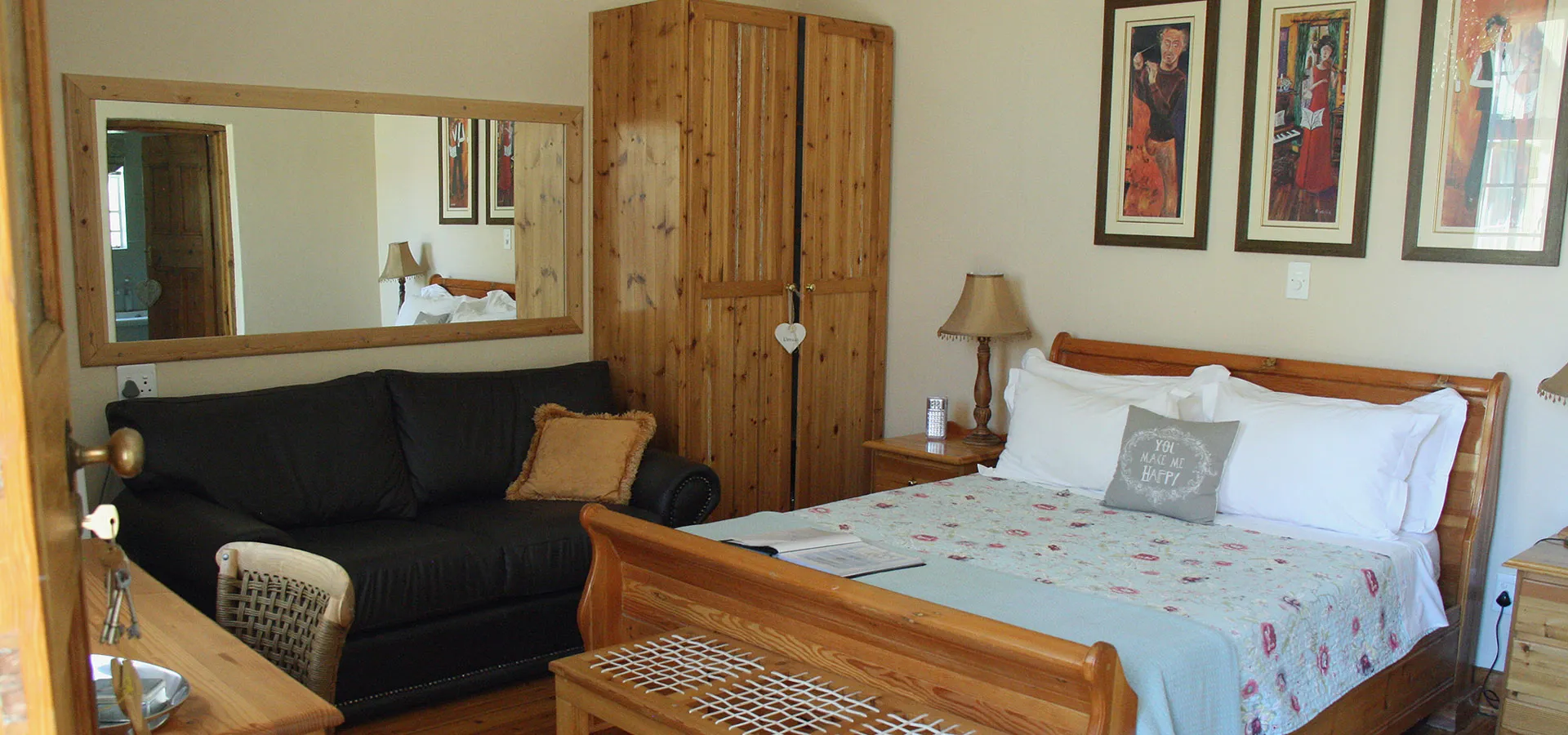 Cozy bedroom with wooden wardrobe bed sofa and wall art