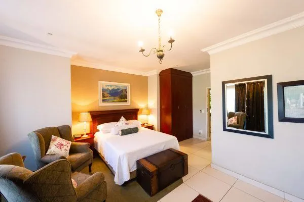 Cozy bedroom with a bed two armchairs and a wooden wardrobe