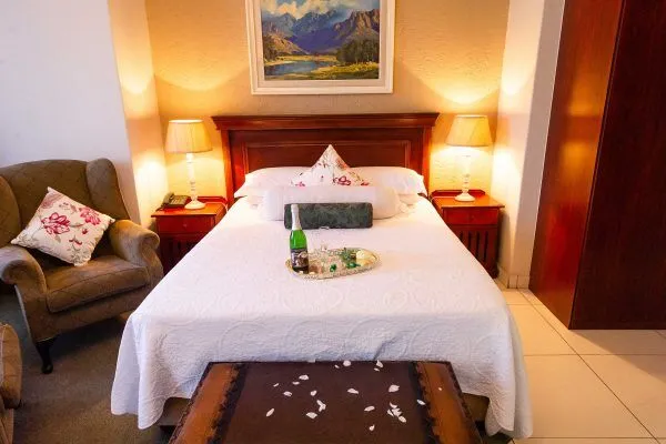 Cozy bedroom with a decorated bed armchair and bedside tables with lamps