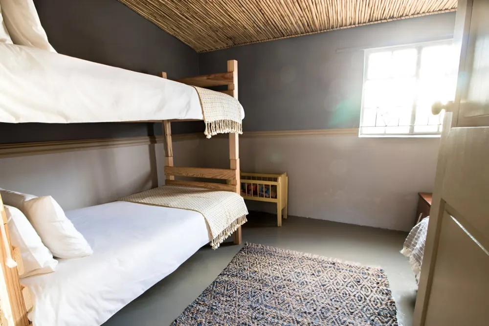 Cozy bedroom with wooden bunk beds woven rug and natural light