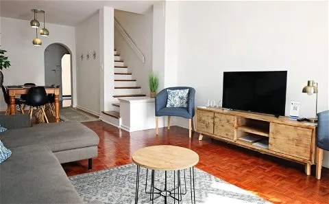 Modern living room with sectional sofa TV and staircase in background