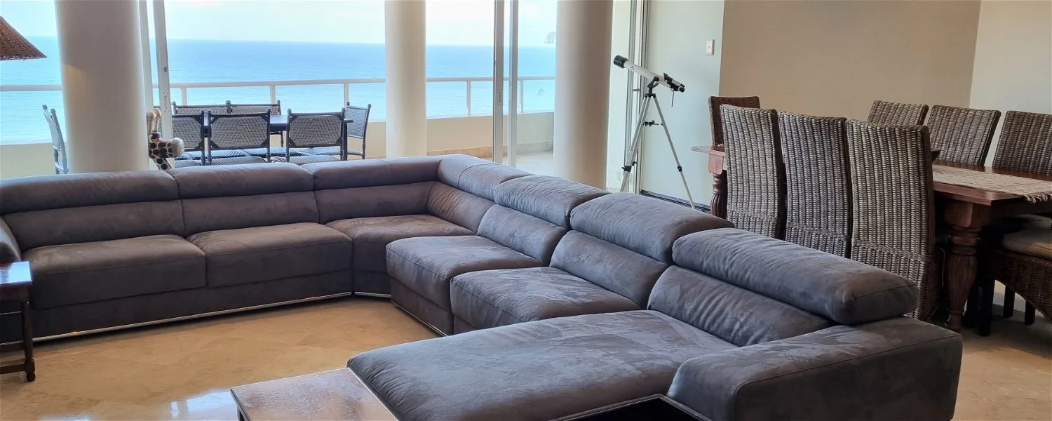 Large gray sectional sofa in a modern living room with ocean view
