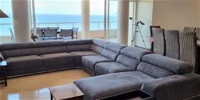 Large gray sectional sofa in a modern living room with ocean view
