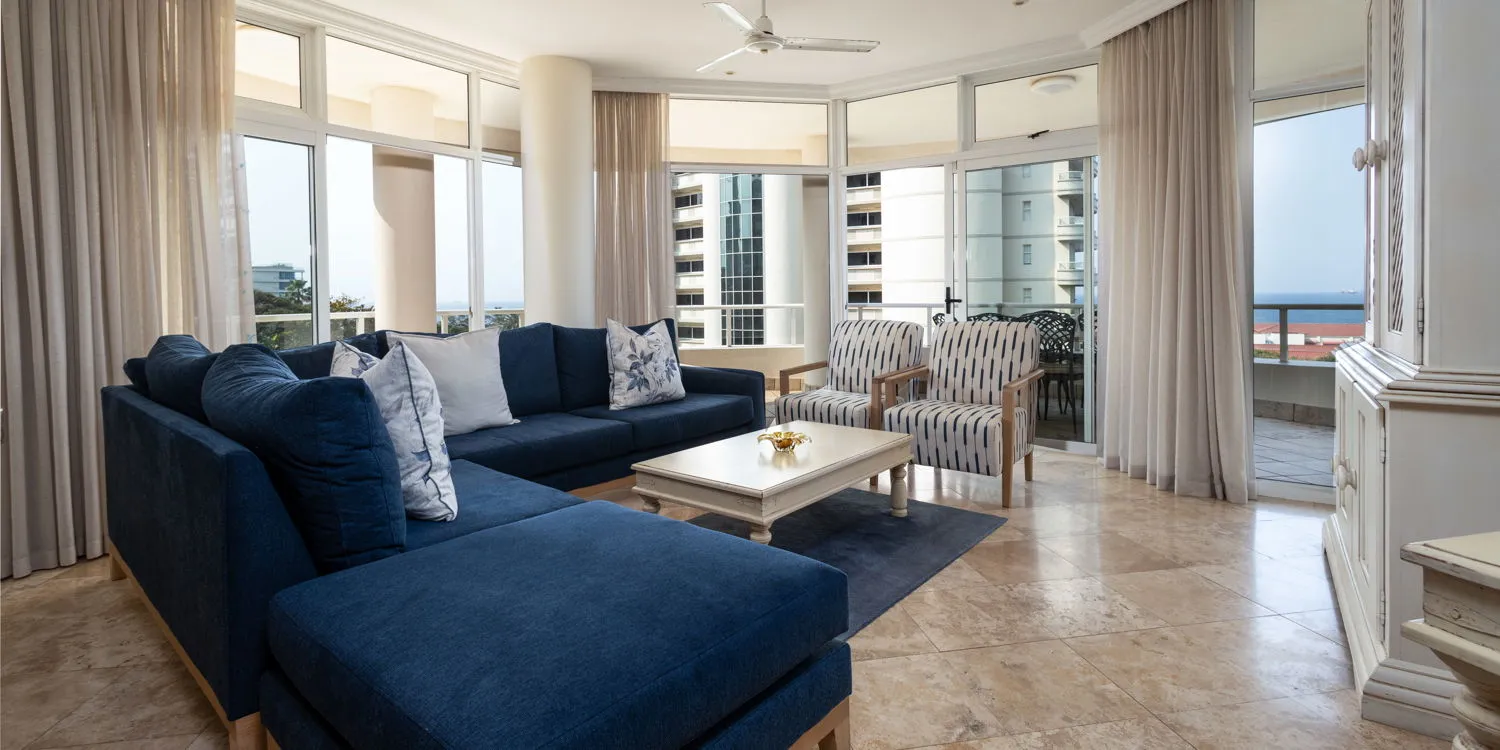 Modern living room with blue furniture large windows and ocean view