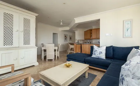 Modern living room with blue sofa coffee table and open kitchen area
