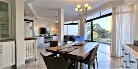 Modern openplan kitchen dining and living area with large windows and ocean view
