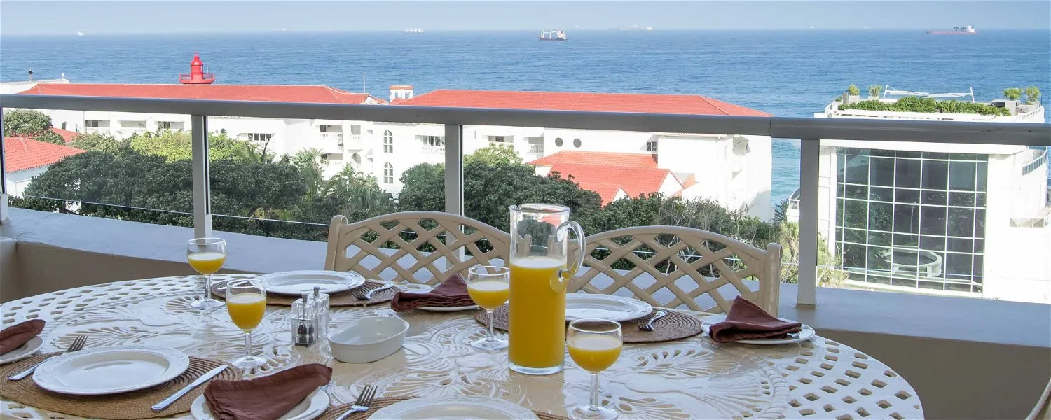 Outdoor table with drinks overlooking the ocean and buildings