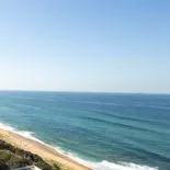 Sandy beach with waves and clear blue sky