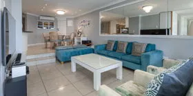 Modern living room with blue sofas white coffee table and dining area