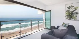 Modern living room with ocean view through large open glass doors