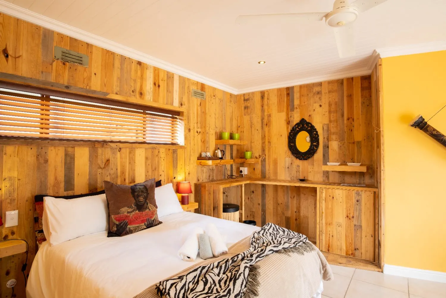Wooden bedroom with zebra print blanket African pillow and yellow accent wall